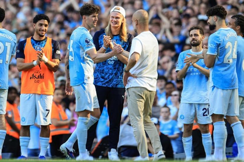 Manchester City's Norwegian striker #09 Erling Haaland (C) looks on as Manchester City's English defender #05 John Stones (2nd L) shakes hands with Manchester City's Spanish manager Pep Guardiola (centre R) after he went through a guard of honour during the English Premier League football match between Manchester City and Aston Villa at the Etihad Stadium in Manchester, north west England, on May 24, 2026.  Darren Staples / AFP