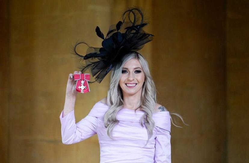 English professional darts player Fallon Sherrock poses with their medal after being appointed a Member of the Order of the British Empire (MBE) following an investiture ceremony at Windsor Castle on November 1, 2023.  Andrew Matthews / POOL / AFP