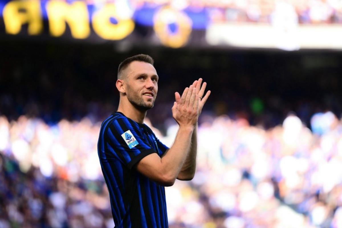 Inter Milan's Dutch defender #6 Stefan De Vrij applauds supporters as Inter Milan's players perpare to celebrate their 21st scudetto (Italian Championship victory) at San Siro stadium after the Italian Serie A football match between Inter Milan and Hellas Verona in Milan, on May 17, 2026.  Marco BERTORELLO / AFP