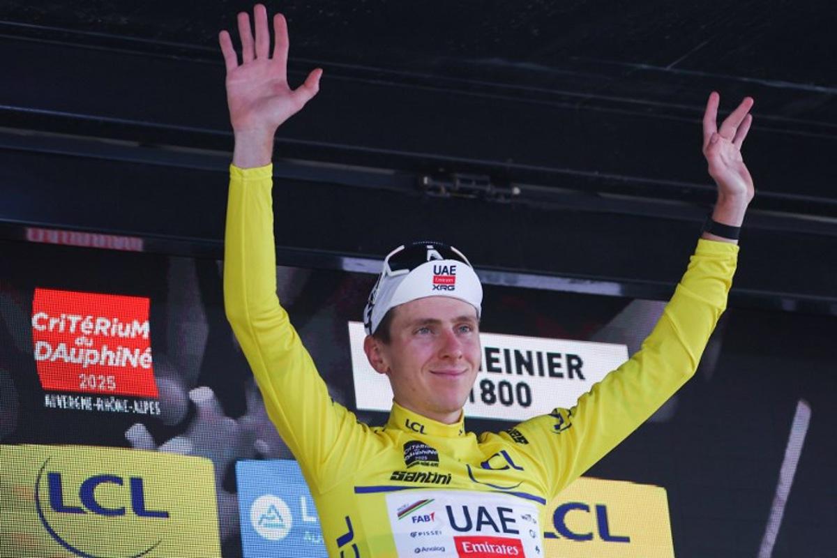 UAE Team Emirates XRG's Slovenian rider Tadej Pogačar celebrates wearing the overall leader's yellow jersey on the podium of the 7th stage of the 77th edition of the Criterium du Dauphine cycling race, 131,6 km between Grand-Aigueblanche and Valmeinier, on June 14, 2025.  Anne-Christine POUJOULAT / AFP
