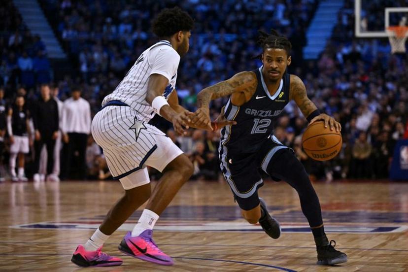 Memphis Grizzlies' US point guard #12 Ja Morant (R) dribbles past Orlando Magic's US shooting guard #11 Jase Richardson (L) during the 2025/2026 NBA season basketball match between the Memphis Grizzlies and Orlando Magic at the O2 Arena in London on January 18, 2026.  Glyn KIRK / AFP