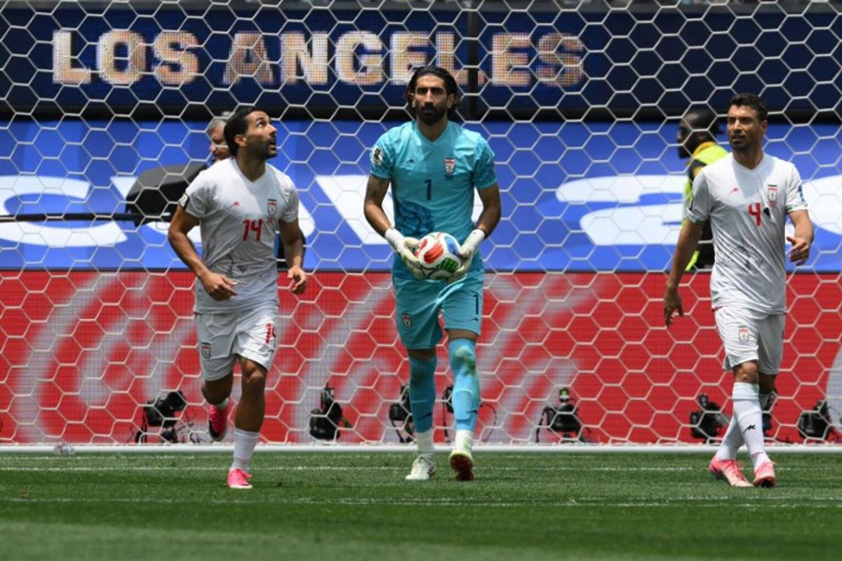 Iran's goalkeeper #01 Alireza Beiranvand holds the ball next to teammates midfielder #14 Saman Ghoddos and defender #04 Shojae Khalilzadeh during the 2026 World Cup Group G football match between Belgium and Iran at the Los Angeles Stadium in Inglewood on June 21, 2026.   Patrick T. Fallon / AFP