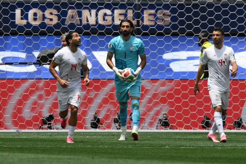 Iran's goalkeeper #01 Alireza Beiranvand holds the ball next to teammates midfielder #14 Saman Ghoddos and defender #04 Shojae Khalilzadeh during the 2026 World Cup Group G football match between Belgium and Iran at the Los Angeles Stadium in Inglewood on June 21, 2026.   Patrick T. Fallon / AFP