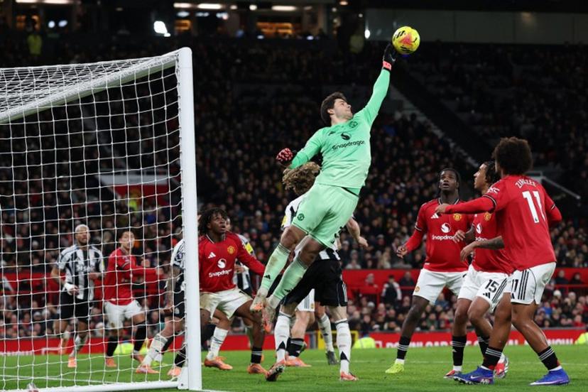 Manchester United's Belgian goalkeeper #31 Senne Lammens fails to push the ball away but is fouled during the English Premier League football match between Manchester United and Newcastle United at Old Trafford in Manchester, north west England, on December 26, 2025.  Darren Staples / AFP