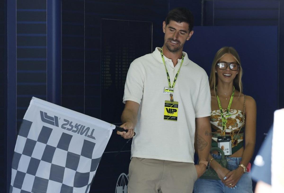 Belgian goalkeeper Thibaut Courtois practices waving the checked flag next to his wive Mishel Gerzig during the Sprint Race of the Formula One Belgian Grand Prix at the Spa-Francorchamps circuit in Spa, on July 26, 2025.  STEPHANIE LECOCQ / POOL / AFP