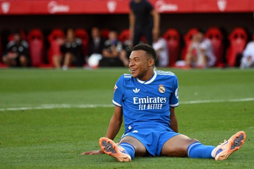 Real Madrid's French forward #10 Kylian Mbappe smiles as he sits on the pitch during the Spanish league football match between Sevilla FC and Real Madrid CF at the Sanchez Pizjuan stadium in Seville on May 17, 2026.  CRISTINA QUICLER / AFP