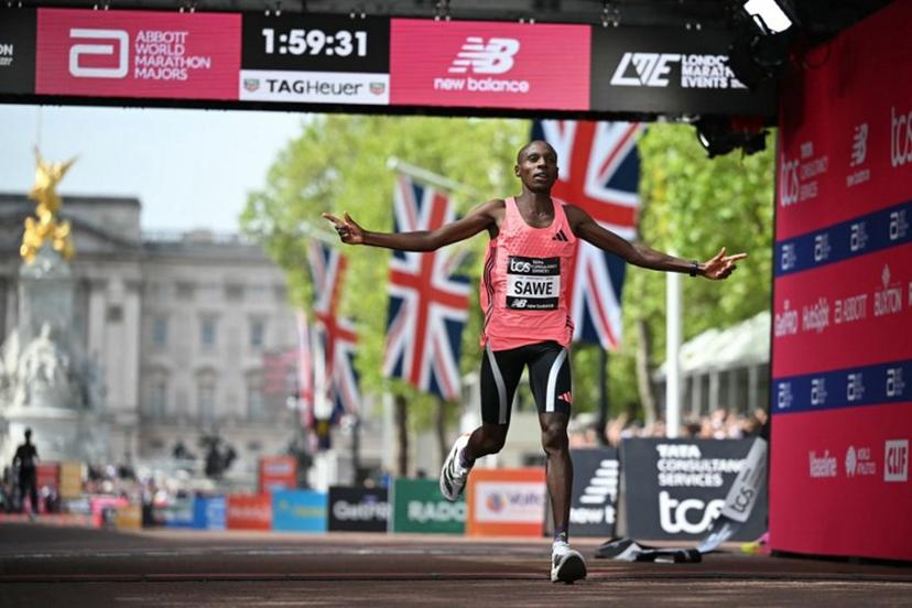 Kenya's Sabastian Sawe crosses the line to win the men's race in a new world record time at the 2026 London Marathon in central London on April 26, 2026. Kenya's Sabastian Sawe broke the two-hour mark for the first time in history on Sunday in winning the London Marathon. JUSTIN TALLIS / AFP