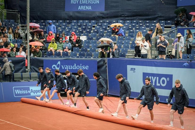 Staff members cover the central court after the final match between Italy's Matteo Berrettini and France's Quentin Halys at the Swiss Open tennis tournament was interrupted due to the rain, in Gstaad, on July 21, 2024.  GABRIEL MONNET / AFP