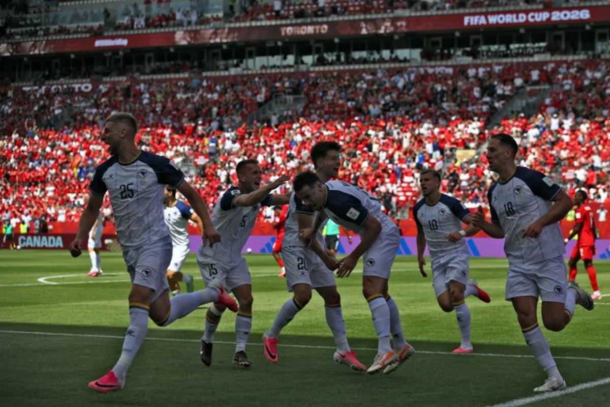 Bosnia-Herzegovina's forward #25 Jovo Lukic (L) celebrates after scoring a goal during the 2026 World Cup Group B football match between Canada and Bosnia and Herzegovina at the Toronto Stadium in Toronto on June 12, 2026.  Cole Burston / AFP