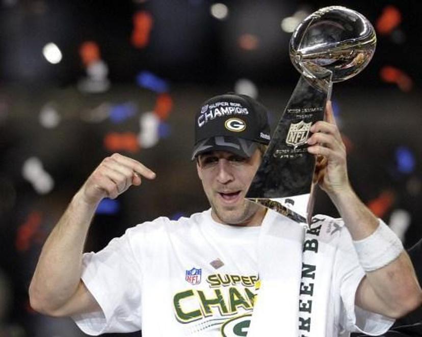 Green Bay Packers quarterback Aaron Rodgers celebrates with the trophy after the Packers defeated the Pittsburgh Steelers 31-25 in the NFL Super Bowl XLV football game at Cowboys Stadium on February 6, 2011 in Arlington, Texas.   AFP PHOTO / TIMOTHY A. CLARY