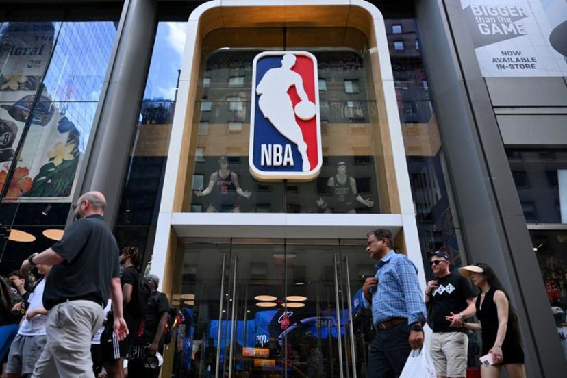 People walk past an NBA fan store with the NBA logo in New York on July 8, 2024.  ANGELA WEISS / AFP