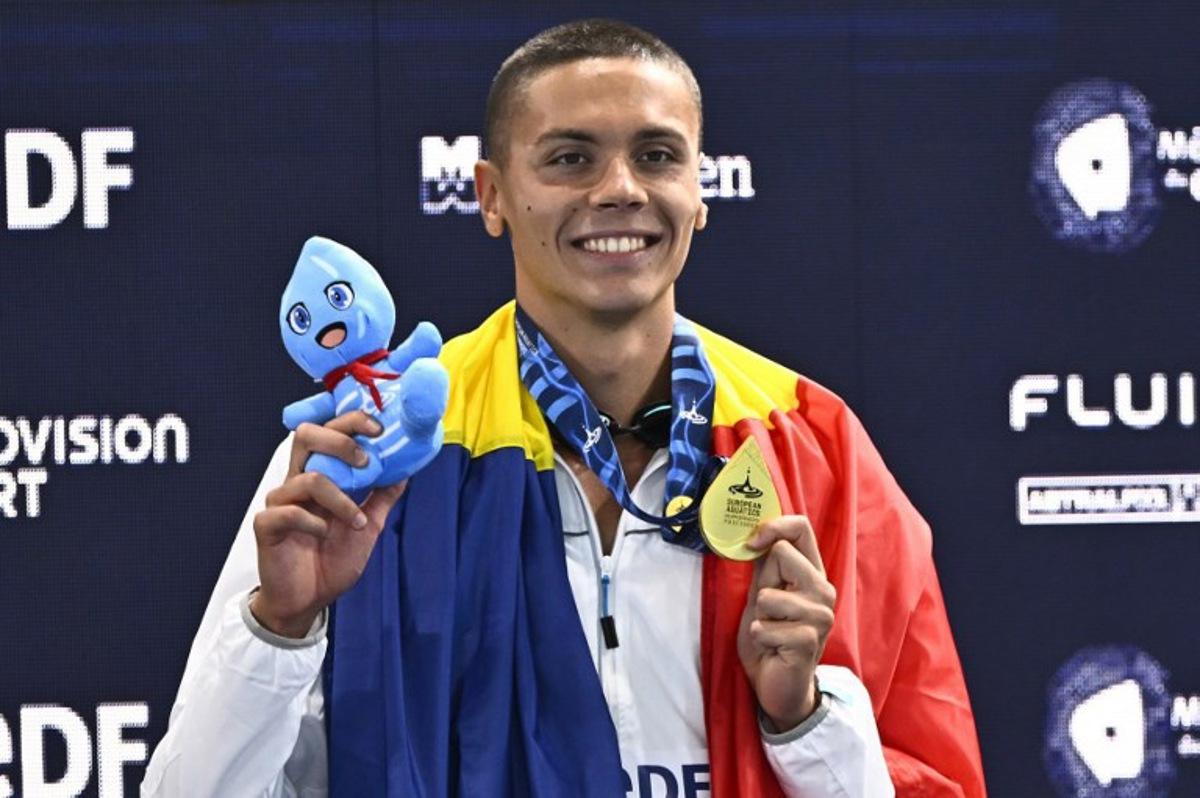 Romania's David Popovici poses with his gold medal on the podium of the men's 100m freestyle swimming event during the LEN European Aquatics Championships at the Olympic Aquatic Centre in Saint-Denis, northern suburbs of Paris, on August 12, 2026.  JULIEN DE ROSA / AFP