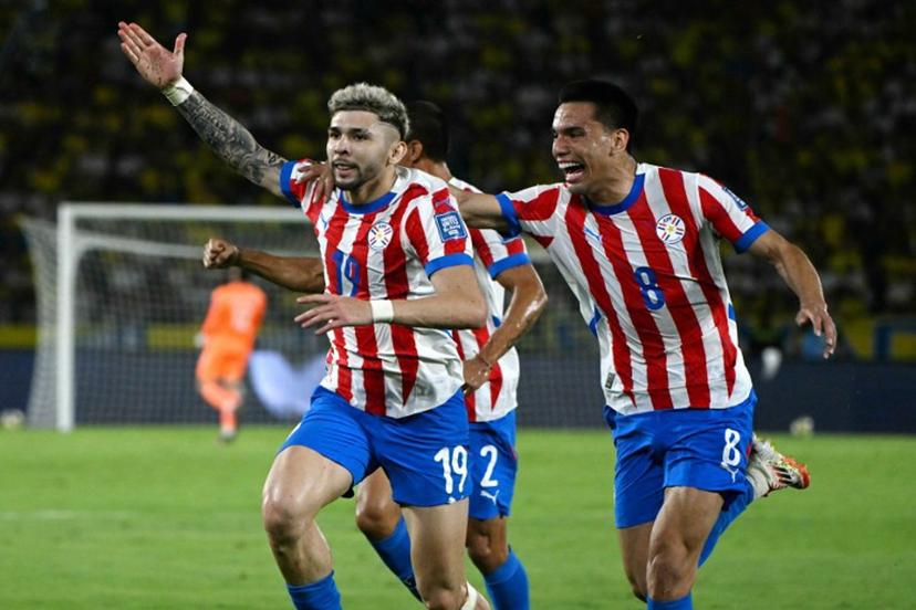 Paraguay's forward #19 Julio Enciso (L) celebrates next to teammate midfielder #08 Diego Gomez after scoring his team second goal during the 2026 FIFA World Cup South American qualifiers football match between Colombia and Paraguay at the Metropolitano Roberto Melendez stadium in Barranquilla, Colombia, on March 25, 2025.  Luis ACOSTA / AFP