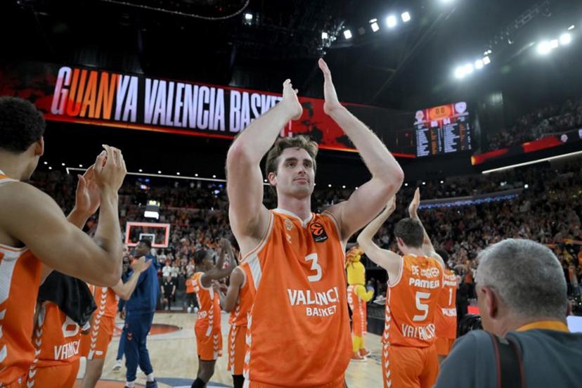 Valencia's players celebrate with supporters their victory 85-84 at the end of the Euroleague basketball match between Valencia Basket and Olympiacos at the Roig arena in Valencia on March 24, 2026.   Jose JORDAN / AFP