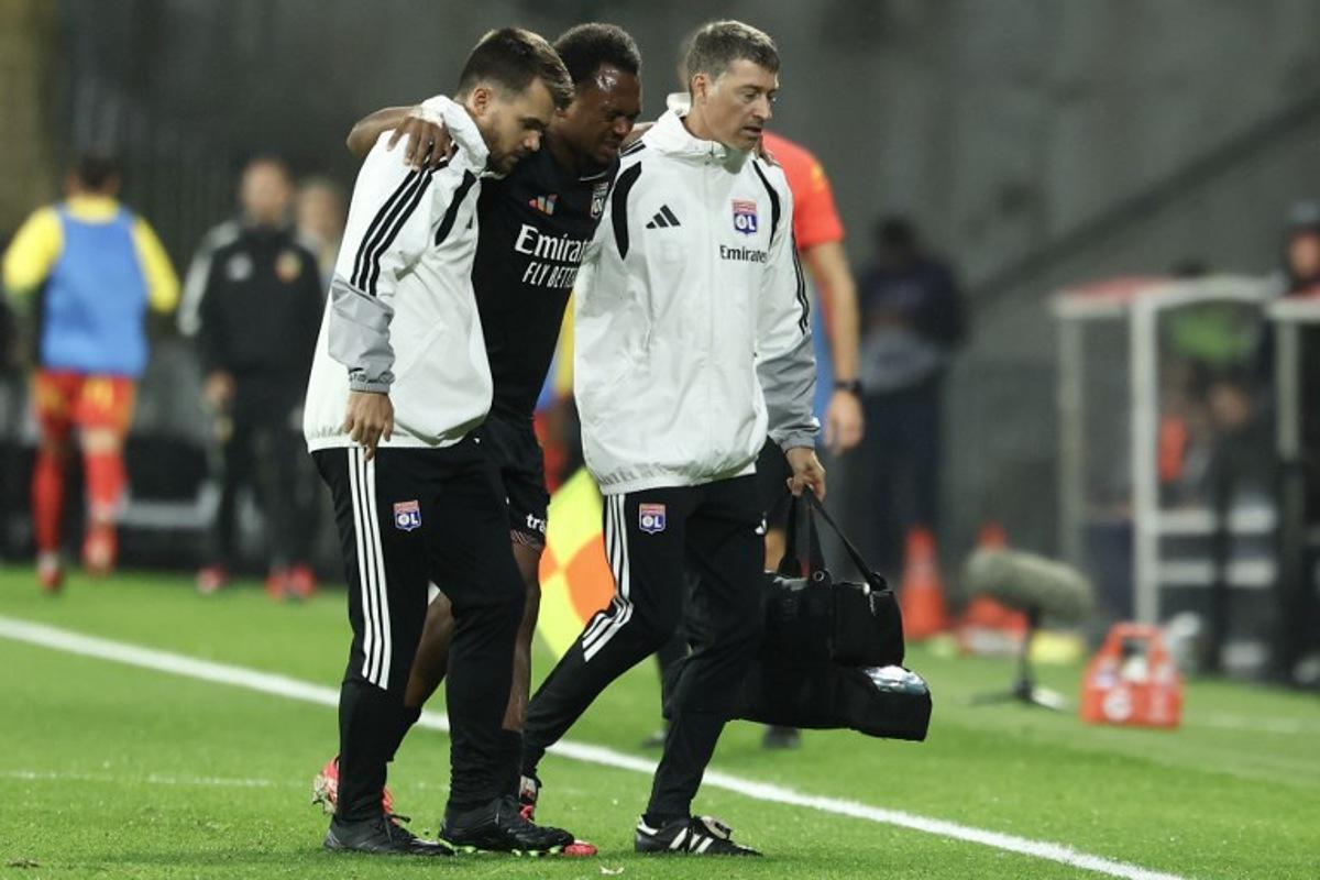 Lyon's Belgian forward #17 Lois Openda leaves the pitch due to an injury during the French L1 football match between RC Lens and Olympique Lyonnais (OL) at the Stade Bollaert-Delelis in Lens, northern France, on October 9, 2026.  Sameer AL-DOUMY / AFP