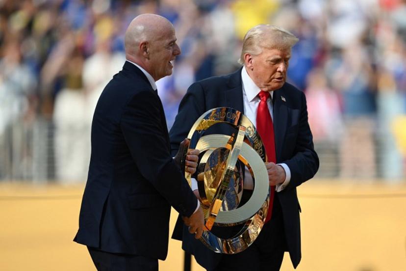 FIFA President Gianni Infantino (L) and US President Donald Trump carry the trophy during the award ceremony for the FIFA Club World Cup 2025 Champions, following the final football match between England's Chelsea and France's Paris Saint-Germain at the MetLife Stadium in East Rutherford, New Jersey on July 13, 2025.  ANGELA WEISS / AFP