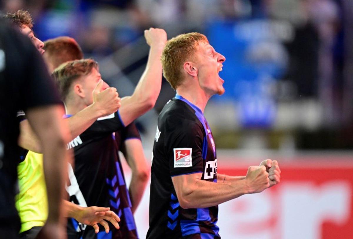SC Paderborn's German defender #17 Laurin Curda (R) celebrates his 2-1 during the German Bundesliga relegation second-leg football match between SC Paderborn 07 and VfL Wolfsburg in Heidenheim on May 22, 2025.  Ina FASSBENDER / AFP