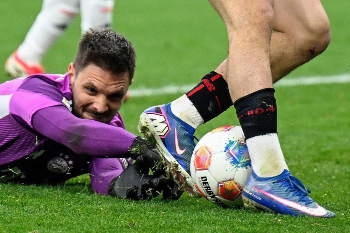 Bayer Leverkusen's Algerian midfielder #30 Ibrahim Maza (R) gets past Bayern Munich's German goalkeeper #26 Sven Ulreich with the ball during the German first division Bundesliga football match between Bayer 04 Leverkusen and FC Bayern Munich in Leverkusen, western Germany on March 14, 2026.  INA FASSBENDER / AFP