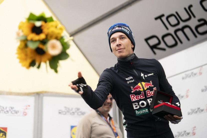 Second placed Red Bull BORA hansgrohe's German Florian Lipowitz, throws flowers during the podium ceremony of the final stage of the Tour of Romandie UCI cycling World tour, 178.2 km from Lucens and to Leysin, in Leysin, Switzerland, on May, 3, 2026.  TIL BUERGY / AFP