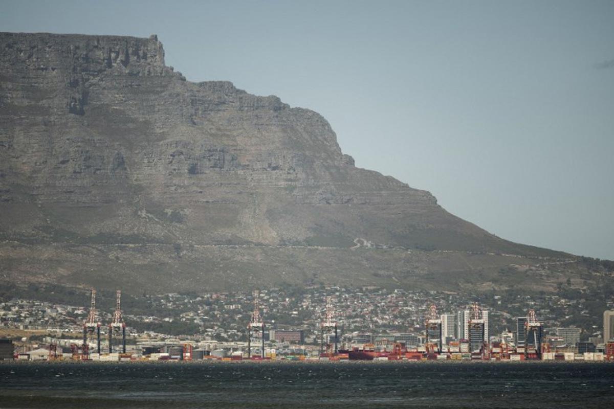 A general view of Table Mountain and the Cape Town City bowl is seen on December 18, 2025. Nestled between spectacular mountains and the Atlantic Ocean, Cape Town has emerged as a growing tourism destination, topping in 2025 the Telegraph and Time Out magazine's rankings of best cities in the world.  Activists say the drive to profit from tourism accommodation is pricing locals out of coveted neighbourhoods, including areas near District Six -- a site long associated with the apartheid-era removals that displaced non-white communities to remote, underdeveloped townships. GIANLUIGI GUERCIA / AFP