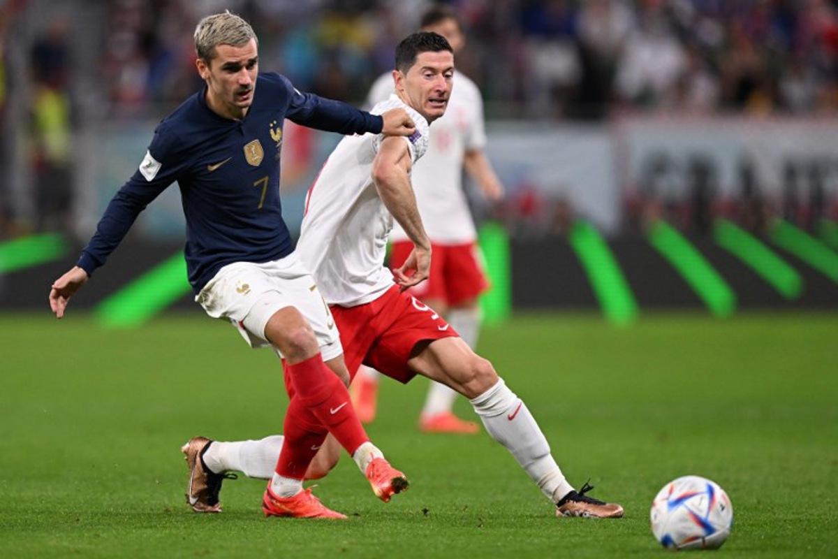 France's forward #07 Antoine Griezmann (L) fights for the ball with Poland's forward #09 Robert Lewandowski during the Qatar 2022 World Cup round of 16 football match between France and Poland at the Al-Thumama Stadium in Doha on December 4, 2022.  Kirill KUDRYAVTSEV / AFP