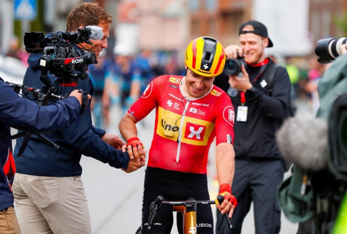 Uno-X Pro Cycling Team's Norwegian rider Fredrik Dversnes (C) is welcomed by Uno-X Mobility's CEO Thor Hushovd (L) after winning the fourth and final stage of the Arctic Cyling Race 2025 in Tromso, Norway, on August 10, 2025.  Rune Stoltz Bertinussen / NTB / AFP