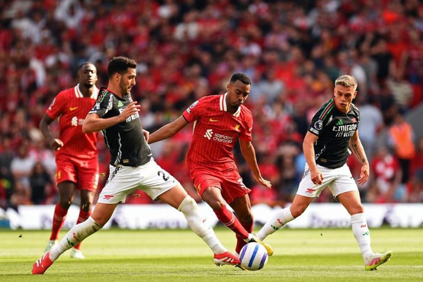 Liverpool's Dutch midfielder #38 Ryan Gravenberch (C) vies with Arsenal's Spanish midfielder #23 Mikel Merino (L) and Arsenal's Belgian midfielder #19 Leandro Trossard (R) during the English Premier League football match between Liverpool and Arsenal at Anfield in Liverpool, north west England on May 11, 2025.  PETER POWELL / AFP