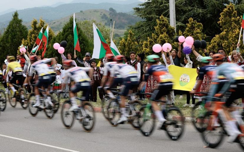 Spectators waving Bulgarian national flags as the pack of rides compete during the 2nd stage of the Giro d'Italia 2026 - Tour of Italy cycling race between Burgas and Veliko Tarnovo, Bulgaria, on May 9, 2026.  Luca Bettini / AFP