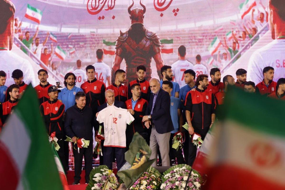 Members of Iran's national football team attend a farewell ceremony ahead of their departure for the 2026 FIFA World Cup, in Tehran on May 13, 2026. The president of the Iranian Football Federation said late May 9 that if Iran dropped out of the World Cup, it would deprive the country of a "major diplomatic asset". World football's governing body FIFA has insisted for weeks that Iran will take part. Iran, who are due to be based in Tucson, Arizona, during the World Cup, face New Zealand, Belgium and Egypt in Group G. The Iranians open their World Cup campaign against New Zealand in Los Angeles on June 15. ATTA KENARE / AFP