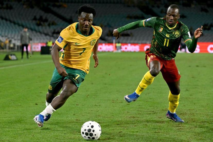 Australia's Nestory Irankunda (L) runs with the ball past Cameroon's Saidou Alioum Moubarak (R) during the international friendly football match between Australia and Cameroon at Stadium Australia in Sydney on March 27, 2026.  SAEED KHAN / AFP