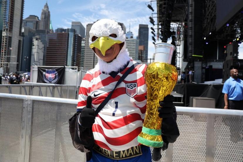 An attendee wearing an eagle mask poses holding an object made to resemble a FIFA World Cup trophy during the US Men's National Team 2026 World Cup roster announcement in New York, on May 26, 2026.  TIMOTHY A. CLARY / AFP