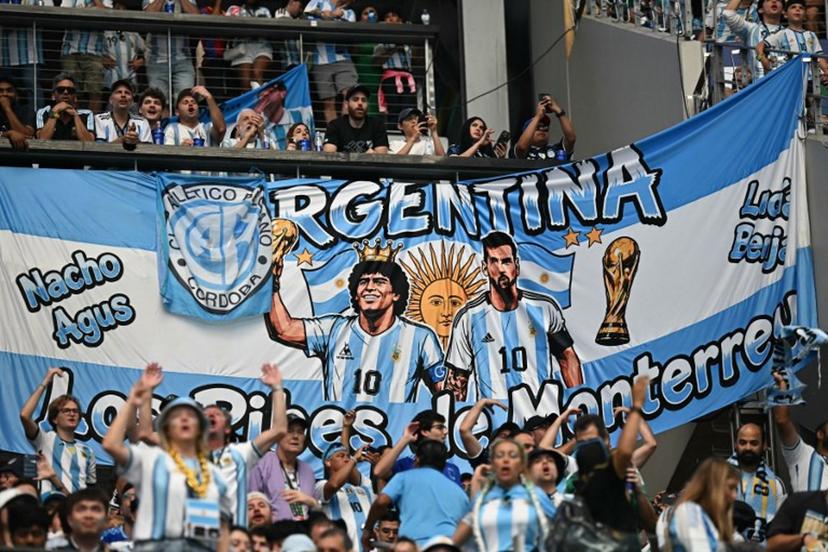 Argentina supporters cheer in front of a banner depicting late Argentine football player Diego Maradona and Argentina's forward #10 Lionel Messi during the 2026 World Cup Group J football match between Argentina and Austria at the Dallas Stadium in Arlington on June 22, 2026.   Paul ELLIS / AFP