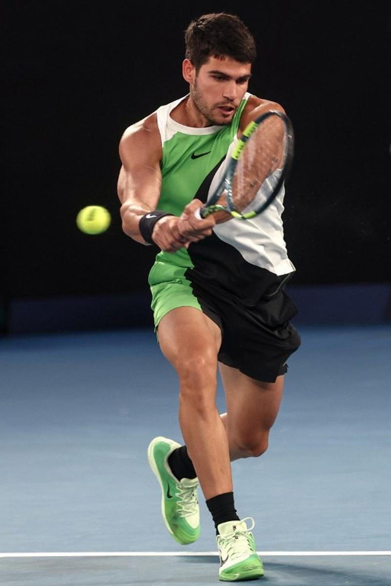 Spain's Carlos Alcaraz hits a return to Australia's Alex De Minaur during their men's singles quarter-final match on day ten of the Australian Open tennis tournament in Melbourne on January 27, 2026.  IZHAR KHAN / AFP