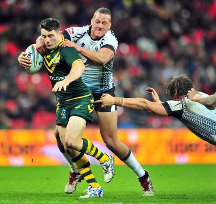 Australia's Cooper Cronk (L) is tackled by Fiji's Kane Evans (2L) and Ashton Sims (R) during the 2013 Rugby League World Cup semi-final match between Australia and Fiji at Wembley Stadium in London, England on November 23, 2013. AFP PHOTO / GLYN KIRK