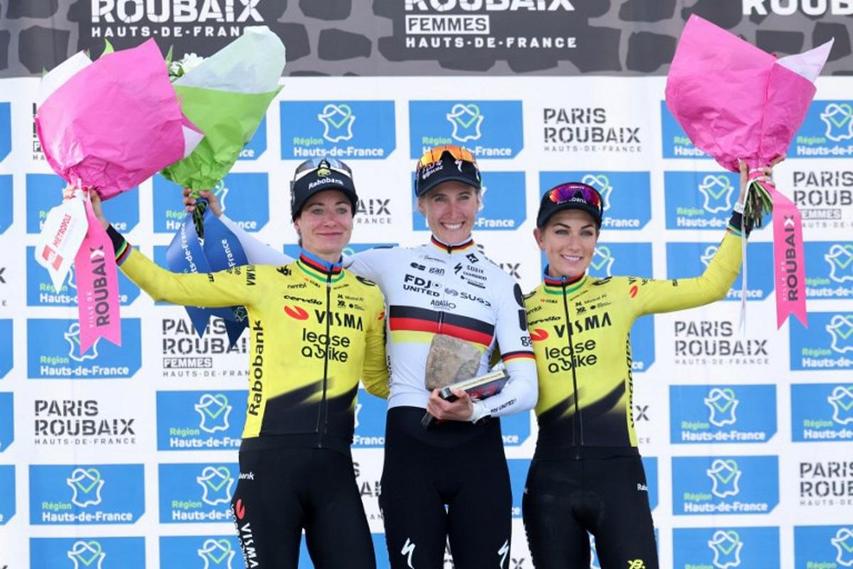 (From L) Second-placed Team Visma - Lease a Bike's Dutch rider Marianne Vos, first-placed FDJ United-SUEZ's German rider Franziska Koch and third-placed Team Visma - Lease a Bike's French rider Pauline Ferrand-Prévot celebrate on the podium of the 6th edition of the Women Paris-Roubaix one-day classic cycling race, 143.1 km between Denain and Roubaix, at the Vélodrome André-Pétrieux in Roubaix, northern France, on April 12, 2026.  Francois LO PRESTI / AFP