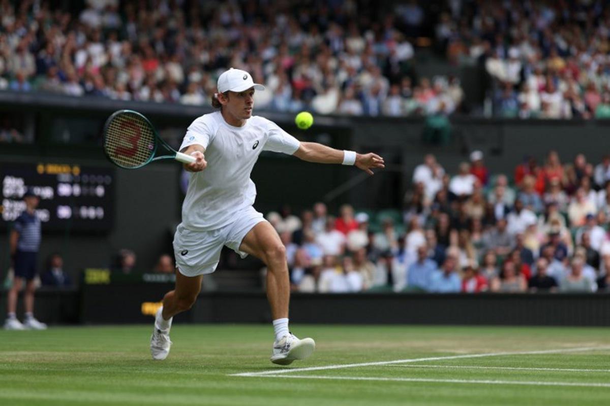 Australia's Alex De Minaur plays a forehand return to Serbia's Novak Djokovic during their men's singles fourth round tennis match on the eighth day of the 2025 Wimbledon Championships at The All England Lawn Tennis and Croquet Club in Wimbledon, southwest London, on July 7, 2025.  Adrian Dennis / AFP
