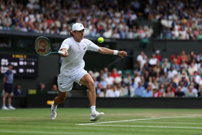 Australia's Alex De Minaur plays a forehand return to Serbia's Novak Djokovic during their men's singles fourth round tennis match on the eighth day of the 2025 Wimbledon Championships at The All England Lawn Tennis and Croquet Club in Wimbledon, southwest London, on July 7, 2025.  Adrian Dennis / AFP