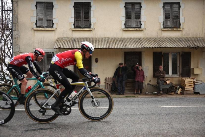 Arkea-B&B Hotels' French rider Thibault Guernalec (L) and Cofidis' Belgian rider Sylvain Moniquet cycle in a breakaway past local residents during the 4th stage of the Paris-Nice cycling race, 163,4 km between Vichy and La Loge des Gardes, on March 12, 2025.  Anne-Christine POUJOULAT / AFP