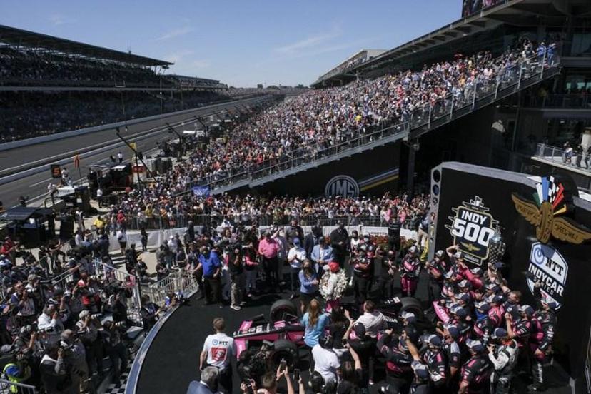 Helio Castroneves(C) celebrates with team members after becoming the fourth driver in history to win the Indianapolis 500 auto race four times at Indianapolis Motor Speedway on May 30, 2021 in Indianapolis. Brazil's Helio Castroneves matched the all-time record by winning his fourth career Indianapolis 500 on Sunday, holding off Alex Palou over the final laps for the victory at age 46. Castroneves -- who also won in 2001, 2002 and 2009 -- joined US legends AJ Foyt, Al Unser Sr and Rick Mears as four-time winners over 200 laps at the famed 2.5-mile (4km) Indianapolis Motor Speedway oval.  Jeff Dean / AFP