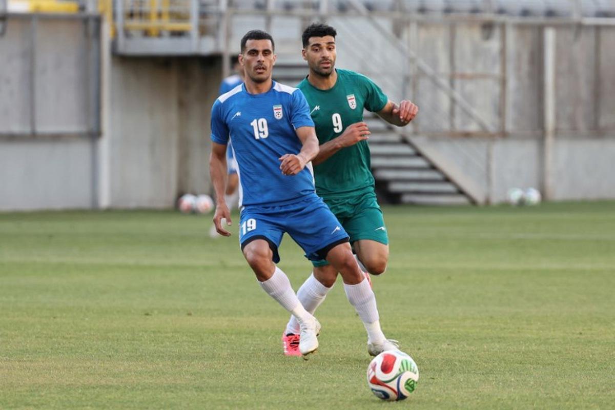 Iran's forward #9 Mehdi Taremi (green) and Iran's defender #19 Milad Mohammadi (blue) practice during a training session as part of the team's preparation for the upcoming football World Cup at the Iranian national team's base camp in Antalya on May 26, 2026.  Oner SAN / AFP