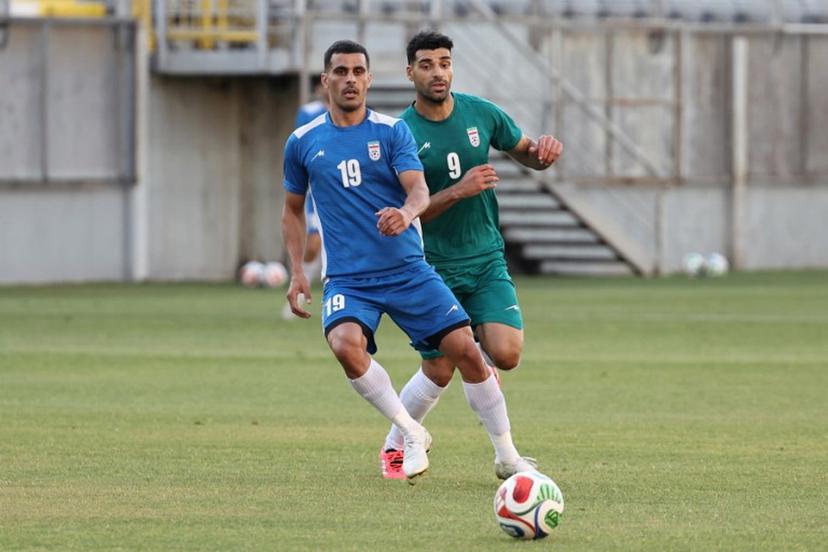 Iran's forward #9 Mehdi Taremi (green) and Iran's defender #19 Milad Mohammadi (blue) practice during a training session as part of the team's preparation for the upcoming football World Cup at the Iranian national team's base camp in Antalya on May 26, 2026.  Oner SAN / AFP