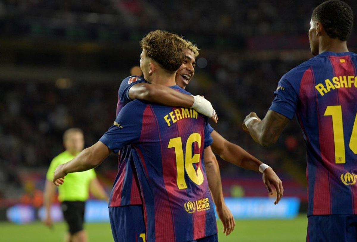 Barcelona's Spanish forward #10 Lamine Yamal celebrates scoring his team's first goal with Barcelona's Spanish midfielder #16 Fermin Lopez and Barcelona's English forward #14 Marcus Rashford during the Spanish league football match between FC Barcelona and Elche CF at Estadi Olimpic Lluis Companys in Barcelona on November 2, 2025.  MANAURE QUINTERO / AFP