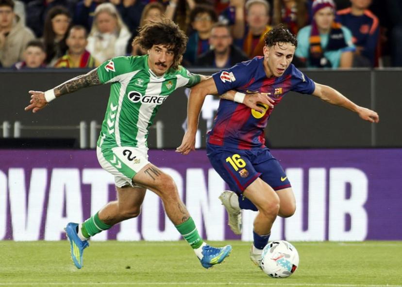 Real Betis' Spanish defender #02 Hector Bellerin and Barcelona's Spanish midfielder #16 Fermin Lopez fight for the ball during the Spanish league football match between FC Barcelona and Real Betis at the Camp Nou Stadium in Barcelona on May 17, 2026.  JAIME REINA / AFP