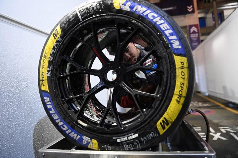 A mechanic cleans a wheel after a pit stop and refueling Porsche Penske Motorsport Thor Team's hypercar #06 during the 2025 Le Mans 24 hour endurance race, at the Le Mans circuit, in northwestern France, on June 14, 2025.  JEAN-FRANCOIS MONIER / AFP