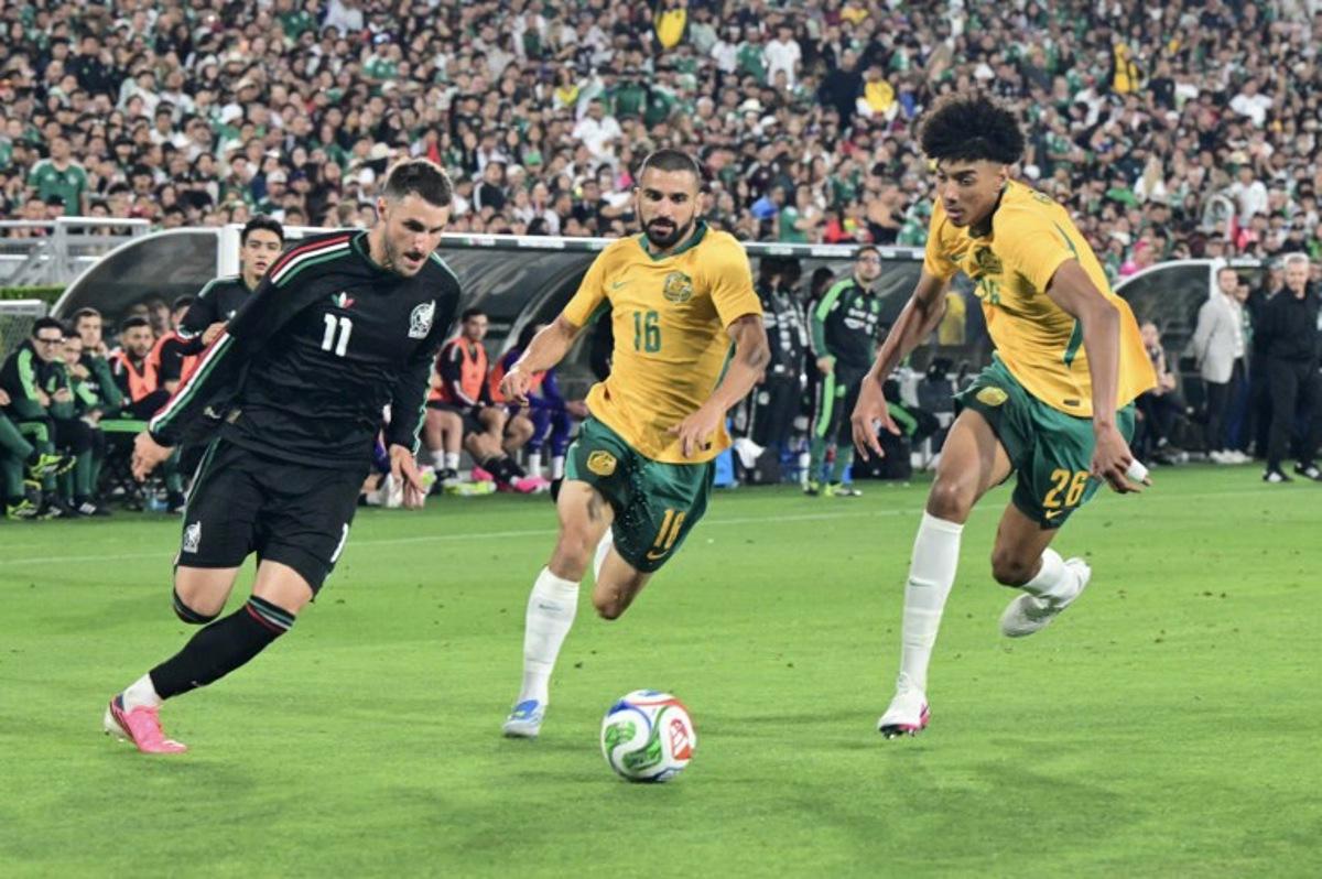 Mexico's forward #11 Santiago Gimenez vies for the ball with Australia's defender #16 Aziz Behich and Australia's defender #26 Lucas Herrington during a friendly football match between Mexico and Australia at The Rose Bowl in Pasadena, California, on May 30, 2026.   Frederic J. Brown / AFP