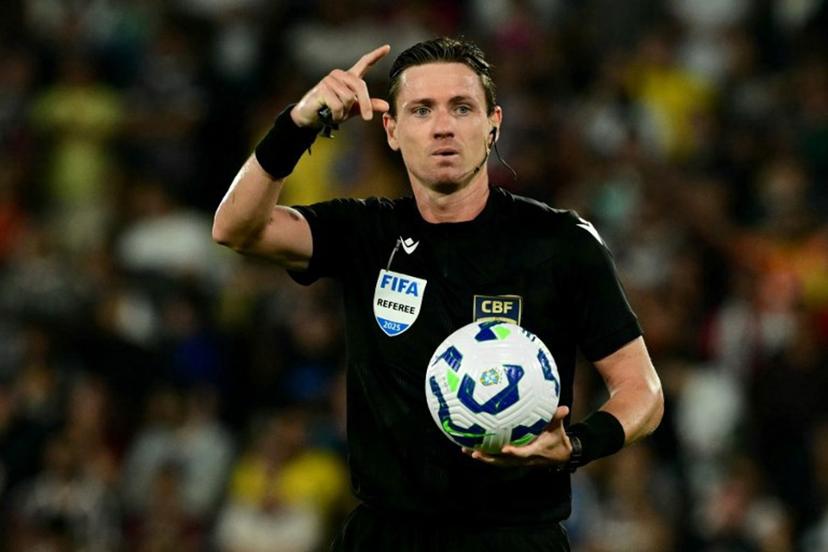 Brazilian referee Ramon Abatti gestures while holding the ball during the Brasileirao Seria A football match between Fluminense and Palmeiras at the Maracana Stadium in Rio de Janeiro, Brazil, on July 23, 2025.  Pablo PORCIUNCULA / AFP