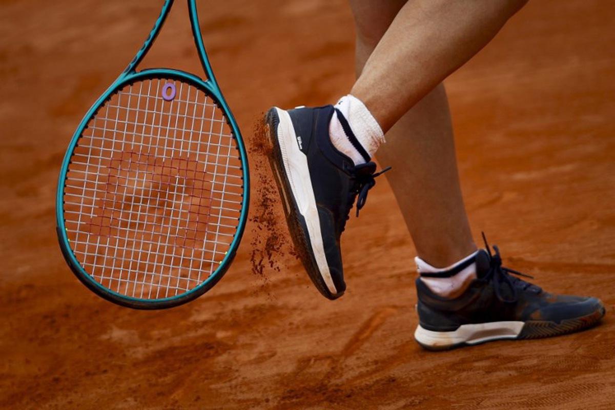 France's Leolia Jeanjean taps her shoe with her racket during her women's singles match against Romania's Elena Ruxandra Bertea at the Billie Jean King Cup play-offs between France and Romania, at Oeiras on the outskirts of Lisbon, on April 9, 2026.  FILIPE AMORIM / AFP