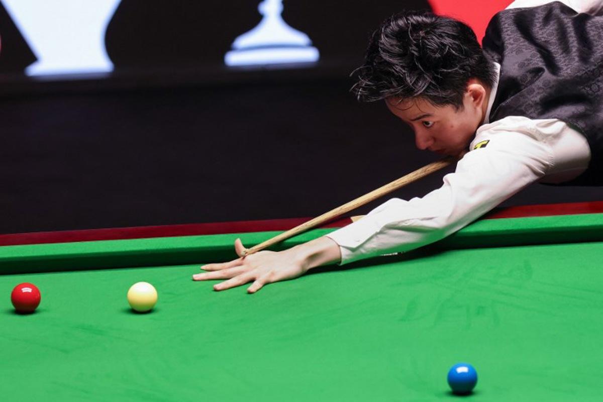 China's Wu Yize plays a shot against England's Shaun Murphy during the World Snooker Championship final round at The Crucible in Sheffield, northern England on May 4, 2026.   Darren Staples / AFP