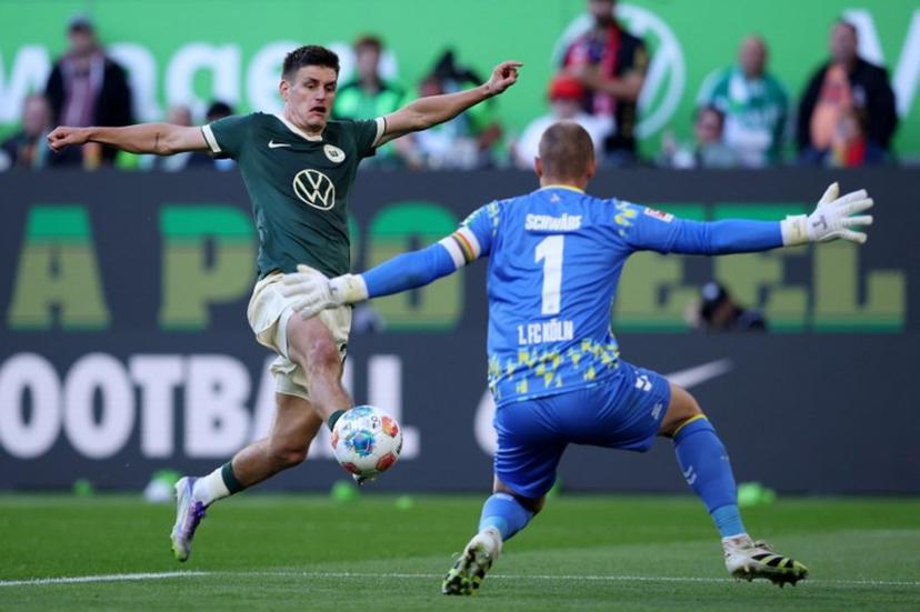 Wolfsburg's Danish defender #21 Joakim Maehle (L) and FC Cologne's German goalkeeper #01 Marvin Schwaebe vie for the ball during the German first division Bundesliga football match between VfL Wolfsburg and FC Cologne in Wolfsburg, northern Germany, on September 13, 2025.  Ronny HARTMANN / AFP