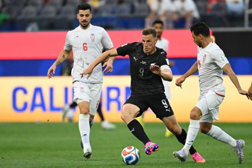New Zealand's forward #09 Chris Wood runs with the ball past Iran's defender #04 Shojae Khalilzadeh during the 2026 World Cup Group G football match between Iran and New Zealand at Los Angeles Stadium in Inglewood on June 15, 2026.   Patrick T. Fallon / AFP